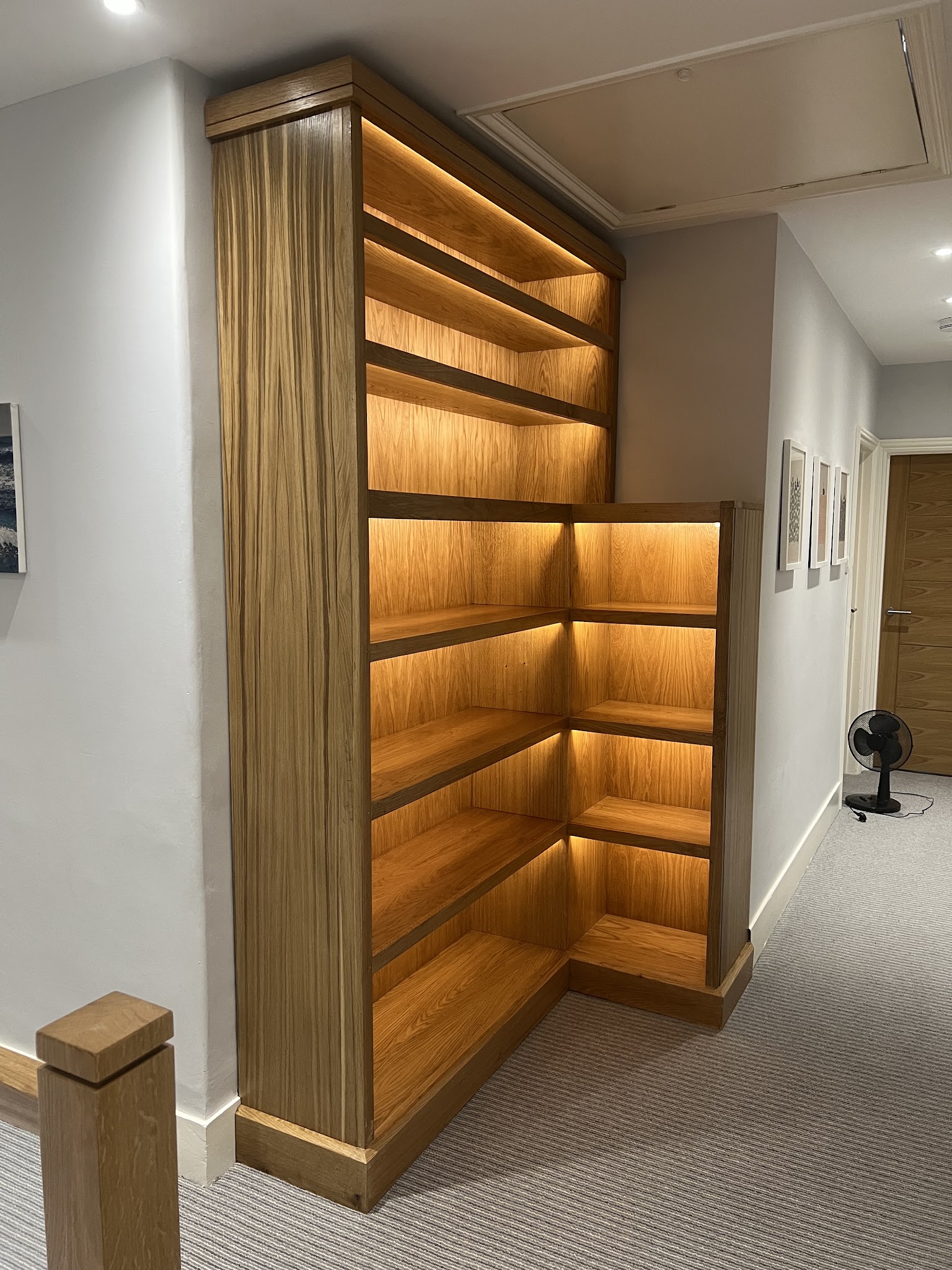 Custom oak shelving with warm integrated LED lighting