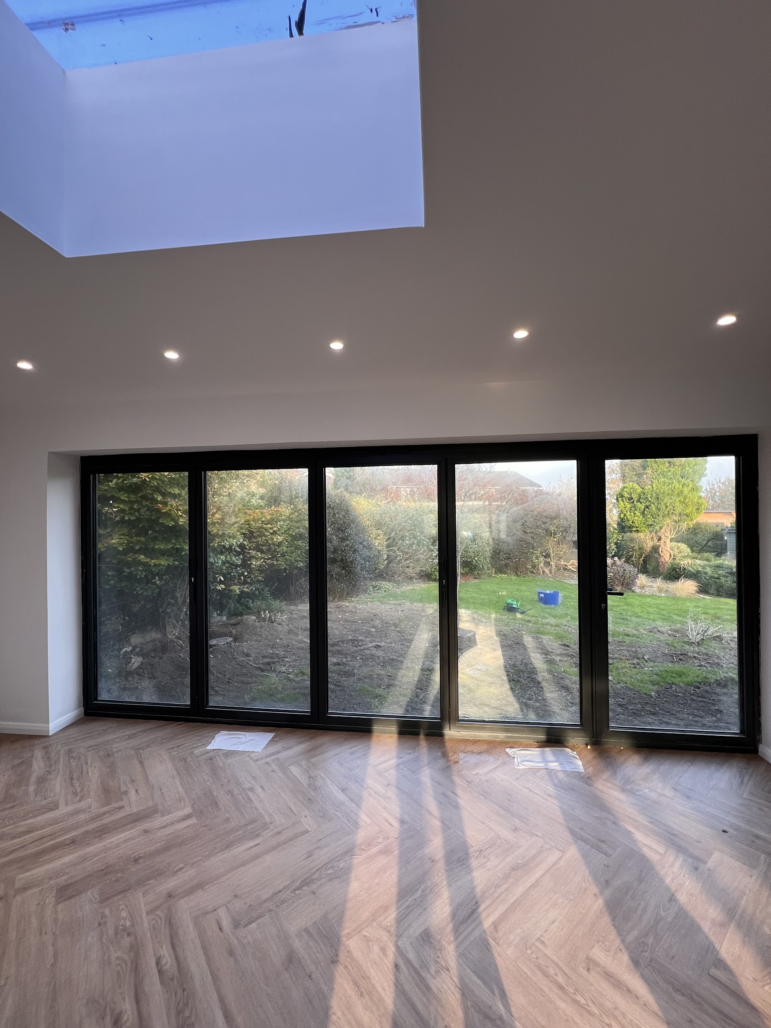 Bright living space opening onto the garden through black-framed glass doors